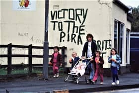 A family walks past IRA graffiti in Coalisland in 1988
