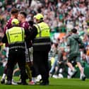 Hearts' Lawrence Shankland is escorted from the pitch by security following the William Hill Premiership match at Celtic Park. (Photo by Andrew Milligan/PA Wire)