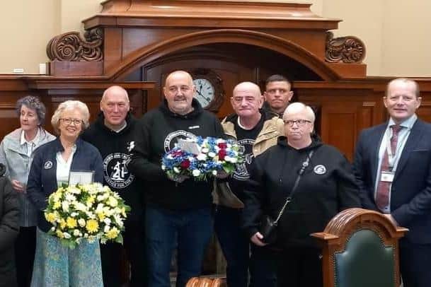 TUV reception for Birmingham Bomb families at Belfast City Hall. Holding the yellow flowers is Julie Hambleton, whose sister Maxine was one of those killed.
On her right in black is Ian William and Glenn Randall (holding blue flowers) who walked from Birmingham to Belfast. On the far right is TUV Deputy Leader Ron McDowell.
On the far left is Mary McCurrie who received the wreaths from the walkers. Her father was murdered by the IRA in east Belfast.