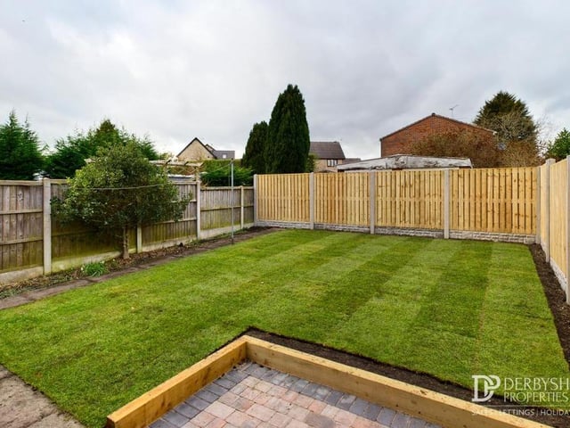 Our final photo shows the lawned garden at the back of the house, and a block-paved patio area. The borders are gravelled, and there are also an outside tap and external light.