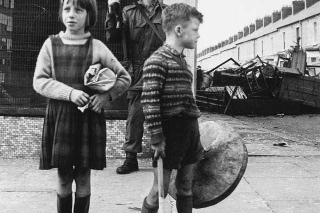 17th August 1969:  A British soldier stands on patrol at a street corner in Belfast, while two children mount their own kerbside guard.  (Photo by Wesley/Keystone/Getty Images)