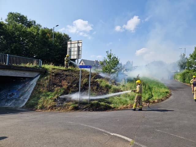 Firefighters battle a grass fire near Tesco's Craigavon, Co Armagh.