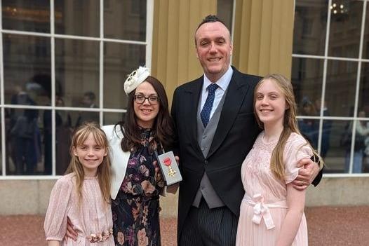 Michael Boyd OBE pictured at Buckingham Palace with wife Cathy and two daughters Rachel and Olivia