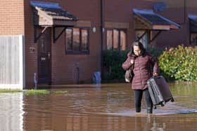 A resident with a suitcase walks through flood water in Retford in Nottinghamshire, after Storm Babet battered the UK, causing widespread flooding and high winds.  The Environment Agency has warned that flooding from major rivers could continue until Tuesday, amid widespread disruption caused by Storm Babet which is posing a 'risk to life' in some areas. Photo: Joe Giddens/PA Wire