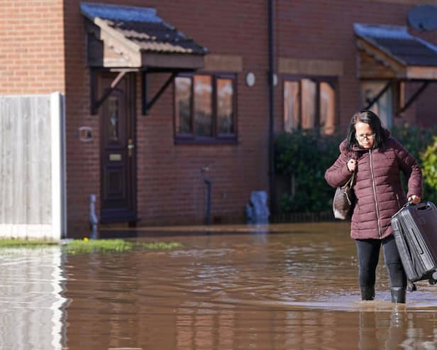 A resident with a suitcase walks through flood water in Retford in Nottinghamshire, after Storm Babet battered the UK, causing widespread flooding and high winds.  The Environment Agency has warned that flooding from major rivers could continue until Tuesday, amid widespread disruption caused by Storm Babet which is posing a 'risk to life' in some areas. Photo: Joe Giddens/PA Wire