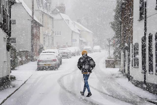 A person walking through a snow flurry in Lenham, Kent.