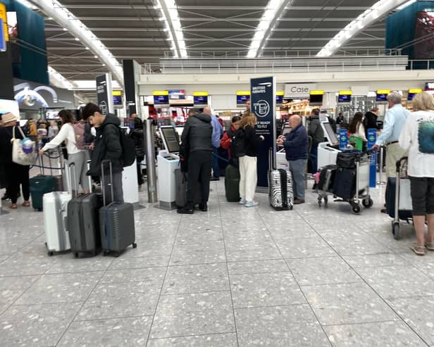 File photo dated 31/03/23 of passengers wait in line to at Terminal 5 of Heathrow Airport, London. A planned relaxation of rules around airline passengers carrying liquids in hand luggage has been delayed by a year.