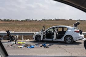 A baby stroller, along with other personal belongings are left on the side of the road next to a car after multiple civilians were killed days earlier in an attack by Hamas militants near the border with Gaza, on October 10, 2023 in Kfar Aza, Israel.
