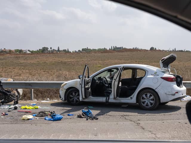 A baby stroller, along with other personal belongings are left on the side of the road next to a car after multiple civilians were killed days earlier in an attack by Hamas militants near the border with Gaza, on October 10, 2023 in Kfar Aza, Israel.