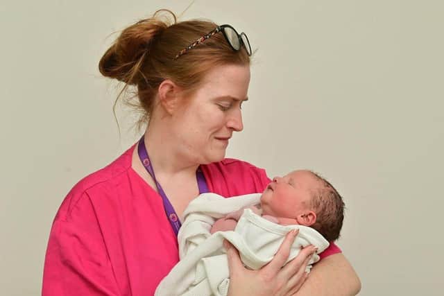 Jude Reid from Lisburn arrived at 0953 at the Ulster Hospital weighing 9lbs and 9oz. Pictured with midwife Kiara McElroy. Photo: Colm Lenaghan/Pacemaker