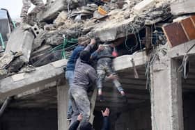 Residents retrieve an injured girl from the rubble of a collapsed building on Monday following an earthquake in the town of Jandaris, near Syria's northwestern city of Afrin in the rebel-held part of Aleppo province. The Red Cross says the priority right now is rescuing people from the rubble (Photo by RAMI AL SAYED/AFP via Getty Images)