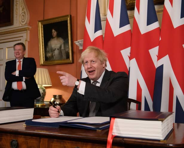 The then UK chief trade negotiator, David Frost looks on as Prime Minister Boris Johnson signs the EU-UK Trade deal at 10 Downing Street, on December 30, 2020. Emphasising that he is not telling the DUP what to do, he says the party must reach its own assessment of the situation. "But it should do so with open eyes”