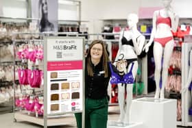 Katie Woodside, a Marks & Spencer colleague at M&S Abbeycentre, celebrates the installation of signage in M&S Fitting rooms encouraging customers to be aware of the signs and symptoms of breast cancer.