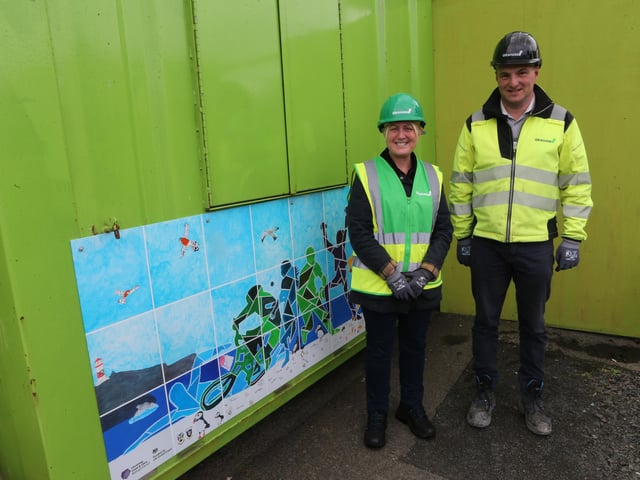 Mayor of Causeway Coast and Glens, councillor Dawn Huggins, and Alan McCullough, project manager at Graham, beside the artwork created by local pupils and displayed on the Ballycastle Leisure Centre hoarding