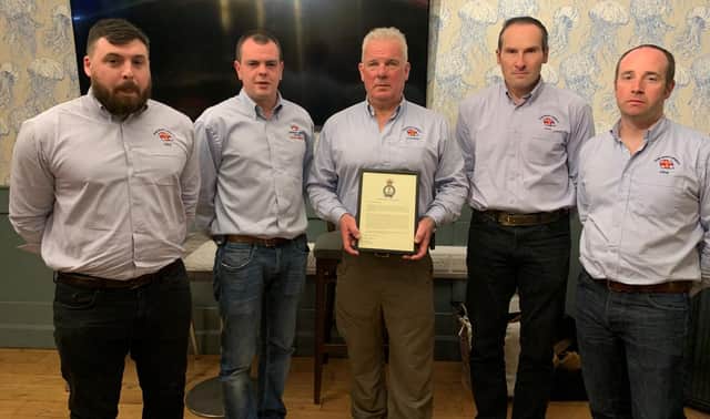 Portrush RNLI Coxswain Des Austin holds the RNLI’s Chief Executive Commendation with lifeboat crew from the station.