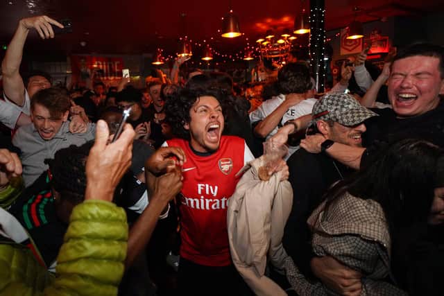 Arsenal supporters celebrate the club becoming Premier League champions. (Photo by AP Photo/Alberto Pezzali)