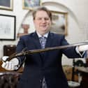 Bloomfield Auctions managing director Karl Bennett with a sword pistol linked to the 1689 Siege of Derry which is among an historic trove of guns set to go under the hammer in Belfast. Duelling pistols, carbines and revolvers are among the collection which has been valued at more than £1 million. They were collected by Antrim man Leslie Martin who died a few years ago. Pic: Phil Magowan/PressEye/PA Wire