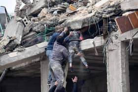 Residents retrieve an injured girl from the rubble of a collapsed building on Monday following an earthquake in the town of Jandaris, near Syria's northwestern city of Afrin in the rebel-held part of Aleppo province. The Red Cross says the priority right now is rescuing people from the rubble (Photo by RAMI AL SAYED/AFP via Getty Images)