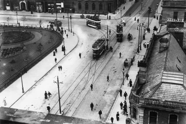 1907:  Trams stopping to pick up passengers at Minehead Square in Belfast.  (Photo by Topical Press Agency/Getty Images)