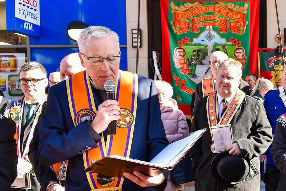 Rev Ron Johnstone speaking at the UDR memorial event in Belfast (with Harold Henning behind him, right, and a banner honouring the two dead soldiers)
