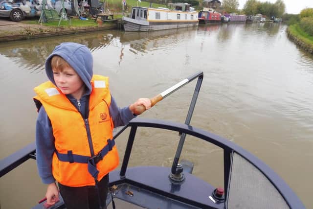 Young Tom steering the boat.