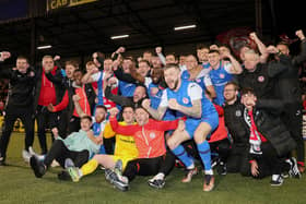 Larne's players and backroom staff celebrate their team winning the league title