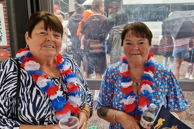 Sisters Liz and Norma Meek take cover in a bus shelter