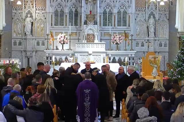 Family and friends surround the coffiin of Odhrán Kelly at the end of his funeral service today in Lurgan.