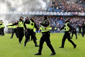 Police officers and stewards form a line to separate the fans following Sunday's Scottish Cup tie between Rangers and Celtic at Ibrox. (Photo by Steve Welsh/PA Wire)