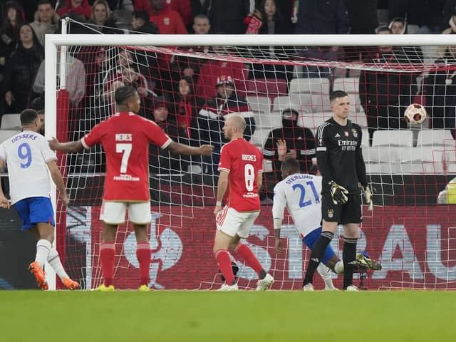 Benfica's goalkeeper Anatoliy Trubin, right, reacts as Rangers' Dujon Sterling, back, celebrates scoring his side's second goal during the Europa League round of 16, first leg, at the Luz stadium in Lisbon