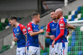Linfield players celebrate with Chris Shields after he netted a second-half penalty against Ballymena United