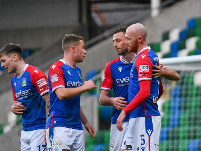 Linfield players celebrate with Chris Shields after he netted a second-half penalty against Ballymena United