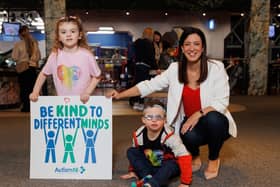From left,  Rebecca Allen (5) and Aaron Allen (9) from Lisburn and Autism NI’s CEO, Kerry Boyd, at the family fun day. The poster reflects the theme of the event.