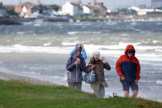Walkers on Co Down's Seapark Beach brave last year's Storm Floris as strong winds ripped across Belfast Lough. Photo: Jonathan Porter/PressEye