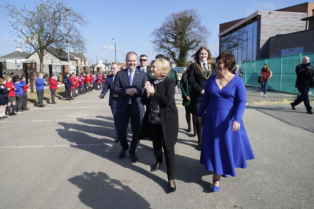 Hillary Clinton (centre), walks with Darren Mornin (left), principal of Limavady High School and Rita Moore (right), principal of St Mary's, as she arrives at Limavady High School
