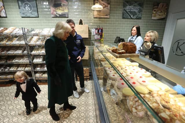 Queen Camilla meets the owner of Knotts Bakery, William Corrie, with his son Fitz (left) and staff during a visit to Lisburn Road in Belfast to meet shop owners and staff