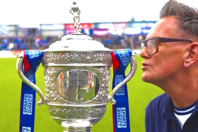 Lifelong Coleraine FC fan, broadcaster Alan Simpson, plants one on the Gibson Cup when it was on show at his club at start of the season. The cup is currently held by NI Premiership champions Larne FC, but he hopes a £2m investment in his club could see it lay hands on the prize soon.