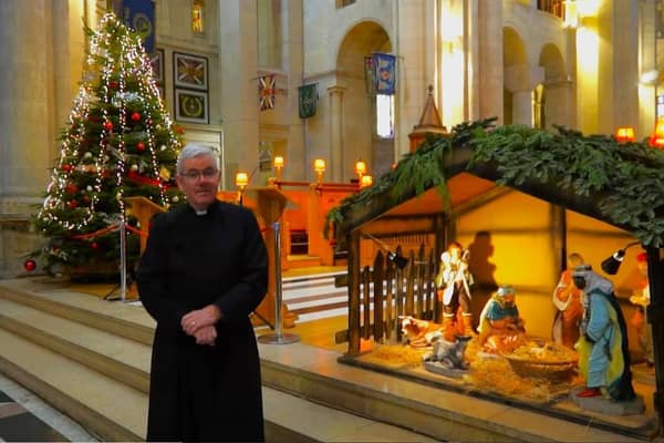 Stephen Forde, the dean of St Anne's in Belfast, delivering a Christmas Day message next to the nativity scene. Alf McCreary attended the Church of Ireland cathedral on Christmas Eve