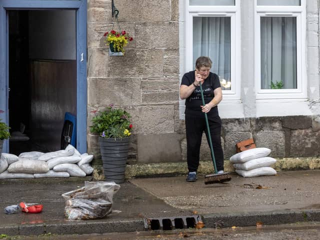 A woman clears away mess left by floodwater in Dumbarton, West Dunbartonshire, as Scotland and northern parts of England are forecast to suffer extreme rainfall and flooding, whilst southern parts of the UK are set to bask in a late blast of summer over the weekend. The Met Office issued an amber weather warning for much of Scotland, and the Scottish Environmental Protection Agency (Sepa) warned against perceiving the situation as "normal autumn". Picture date: Saturday October 7, 2023.  Photo : Robert Perry/PA Wire