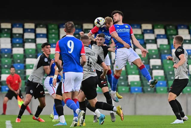 Linfield’s Michael Newberry and Larne’s Sean Graham contest a high ball in the Co Antrim Shield clash at Windsor Park