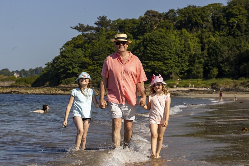 Kingsley Donaldson with his daughters Charlotte (left) and Emilia taking a walk along the beach at Helen's Bay in Bangor, Northern Ireland.