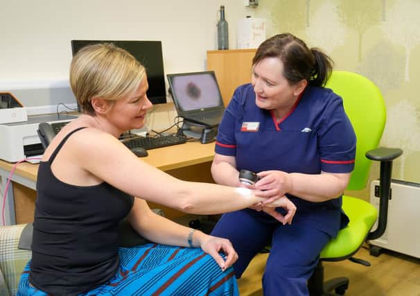 Action Cancer Ambassador Lyn Stevenson has her skin examined by Action Cancer’s Senior Skin Cancer Specialist Iona McCormack using a Dermatoscope in the clinic at Action Cancer House, Belfast.