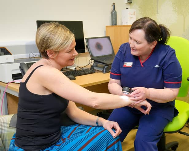 Action Cancer Ambassador Lyn Stevenson has her skin examined by Action Cancer’s Senior Skin Cancer Specialist Iona McCormack using a Dermatoscope in the clinic at Action Cancer House, Belfast.