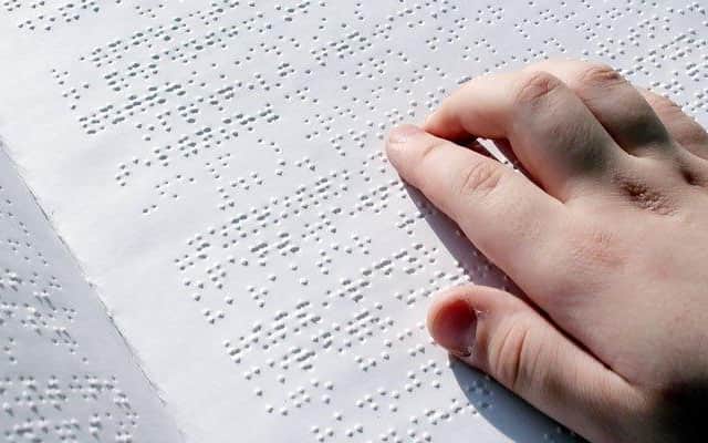 A person reading a braille book