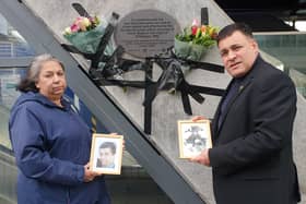 Local residents Janis Rowland and Jonathan Ganesh leave flowers at the scene of the 1996 IRA London Docklands bombing. They are holding photos of Inam Bashir and John Jeffries, who were both killed in the attack. The 28th anniversary of the attack was today, 9 February 2024.
