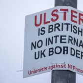 A sign on a lamppost that reads 'Ulster is British - no internal UK Border - Unionists against NI Protocol', opposite the Department of Agriculture, Environment and Rural Affairs (DAERA) in Northern Ireland.