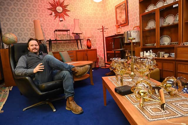 Justin Lowry surrounded by retro items in On the Square Emporium