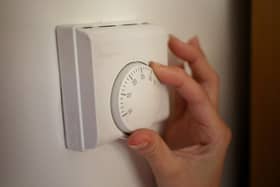 Undated file photo of a person using a central heating thermostat.