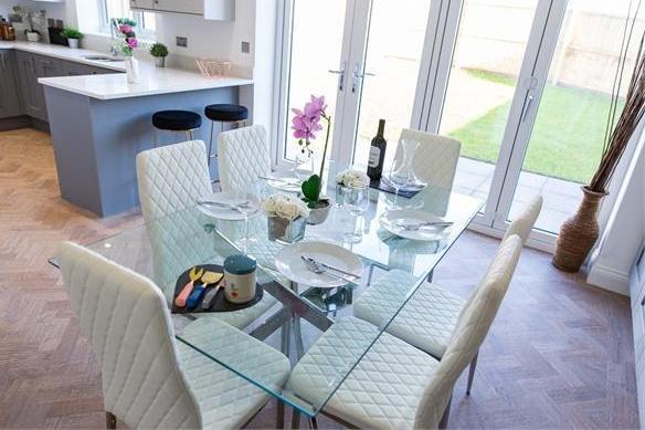 Here is the pleasant dining section of the kitchen/'diner. The bi-folding doors lead outside, where The Durham has a detached double garage, private driveway and manicured lawned gardens.