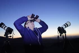 A man scours the night sky with binoculars and camera equipment from the Rock of Dunamase in Co Laois